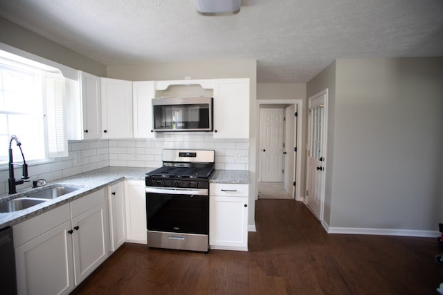 kitchen with white cabinetry, stainless steel appliances, dark wood-type flooring, and sink