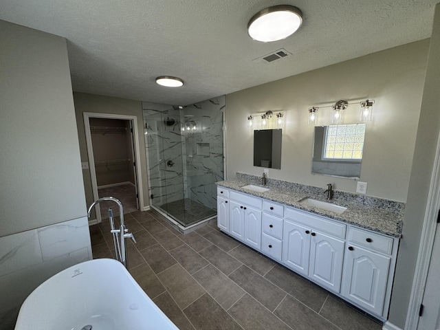 1805 Pointe Ct, Lebanon, TN 37087 - bathroom with a stall shower, a textured ceiling, double vanity, a soaking tub, and a walk in closet