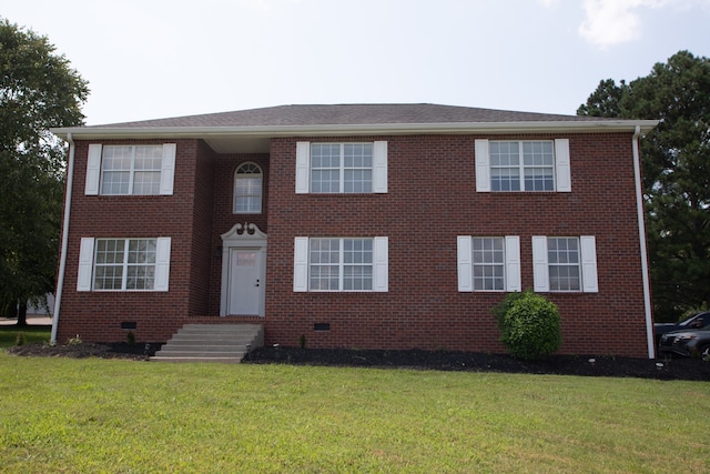 colonial-style house featuring a front yard