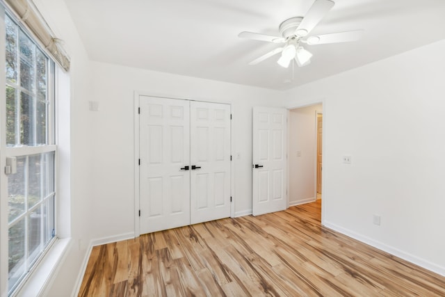 unfurnished bedroom featuring ceiling fan, a closet, and light hardwood / wood-style flooring