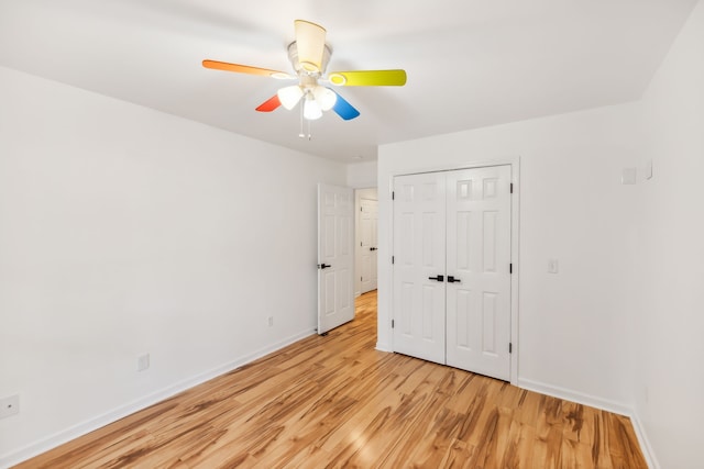 unfurnished bedroom with ceiling fan, a closet, and light wood-type flooring