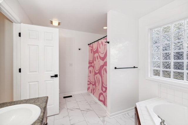 bathroom with vanity and tiled tub