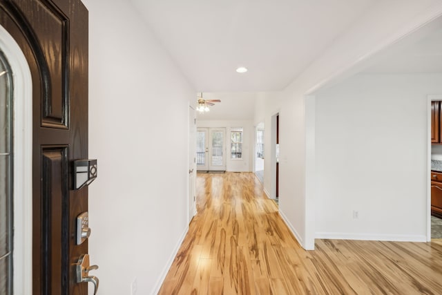 hall with light hardwood / wood-style flooring and french doors