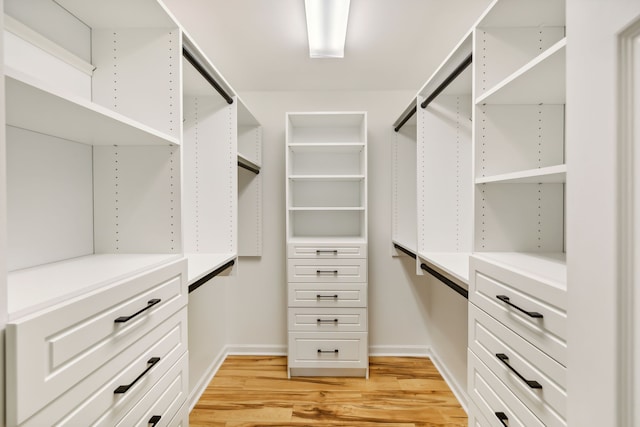 walk in closet with light hardwood / wood-style floors