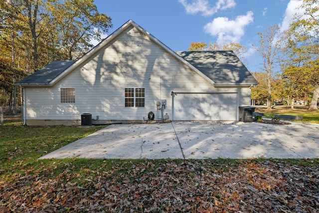 back of house featuring a garage and central AC