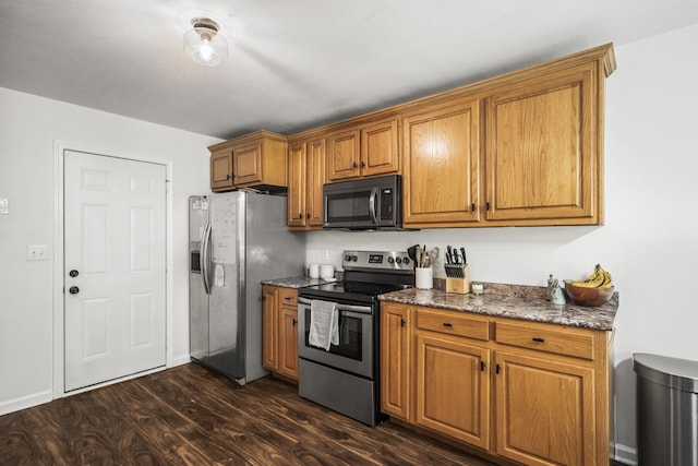 kitchen with stainless steel appliances, stone counters, and dark wood-type flooring