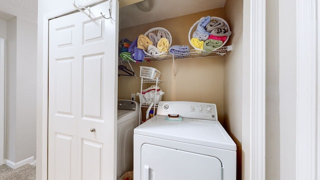 washroom with a textured ceiling and washer and dryer