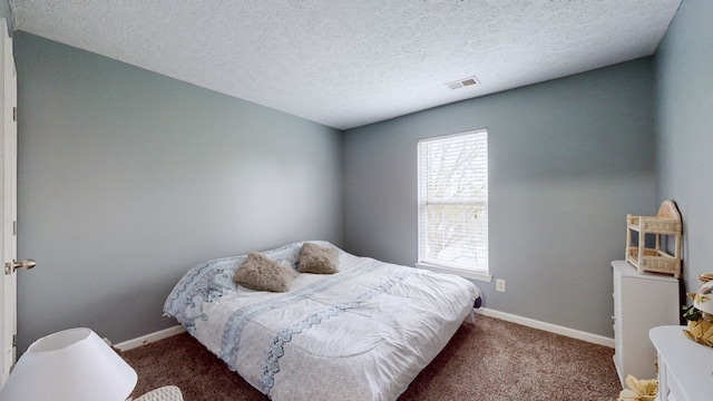 bedroom featuring a textured ceiling and carpet flooring