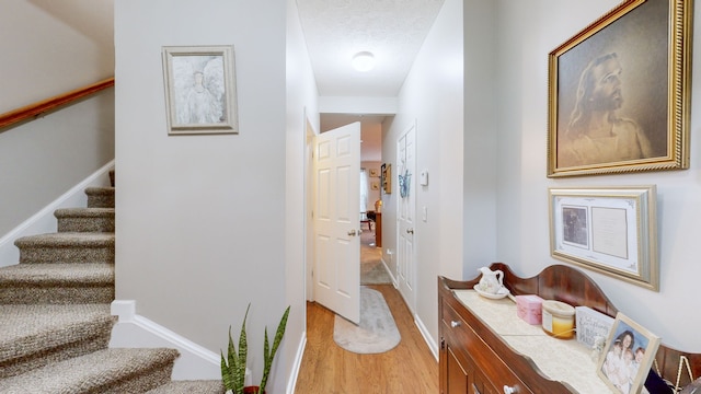 interior space with a textured ceiling and light hardwood / wood-style flooring