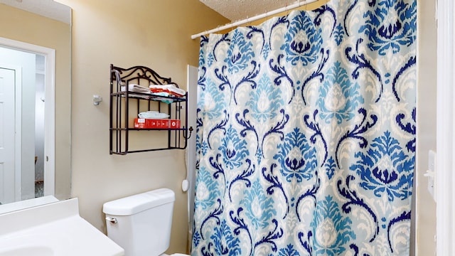 bathroom featuring vanity, walk in shower, a textured ceiling, and toilet