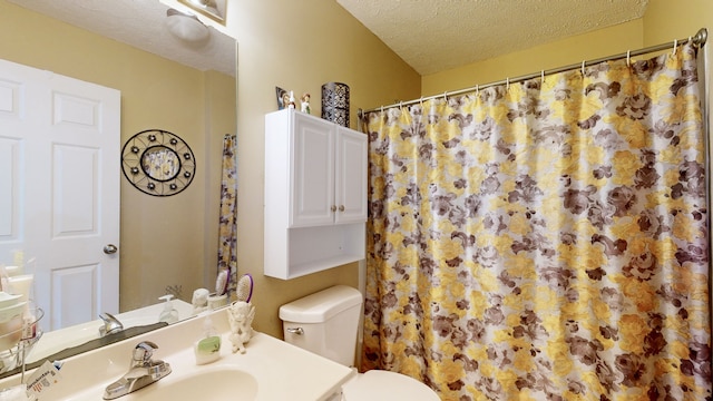 bathroom with curtained shower, vanity, a textured ceiling, and toilet