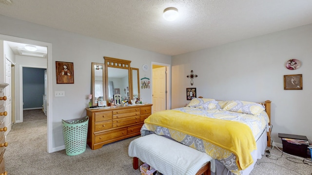 bedroom featuring light colored carpet and a textured ceiling