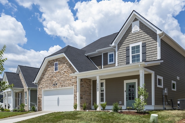 view of front of home with a garage, a porch, a front lawn, and central AC unit