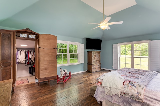 bedroom featuring dark wood-type flooring, vaulted ceiling, ceiling fan, a closet, and a spacious closet