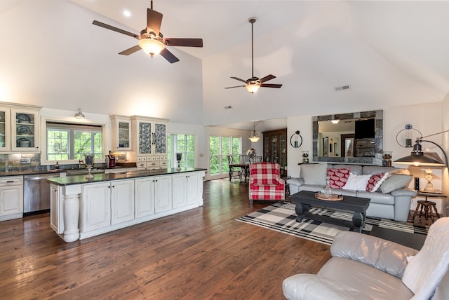 living room with high vaulted ceiling, dark hardwood / wood-style flooring, a healthy amount of sunlight, and ceiling fan