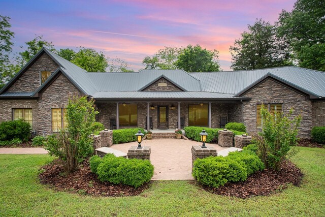884 Pinnacle Hill Rd, Kingston Springs, TN 37082 - view of front facade with stone siding, a patio area, metal roof, and a front lawn
