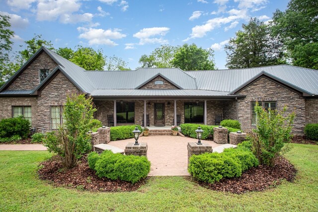 884 Pinnacle Hill Rd, Kingston Springs, TN 37082 - back of property with a patio, metal roof, a lawn, and stone siding