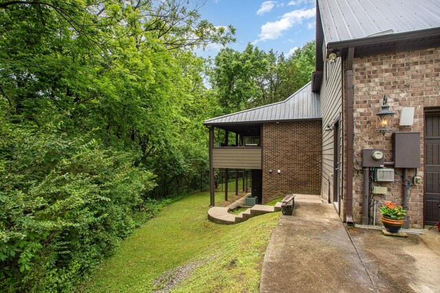 884 Pinnacle Hill Rd, Kingston Springs, TN 37082 - view of property exterior with brick siding, a lawn, and metal roof