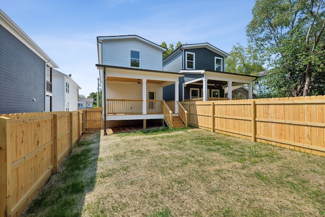 rear view of house with a lawn and ceiling fan