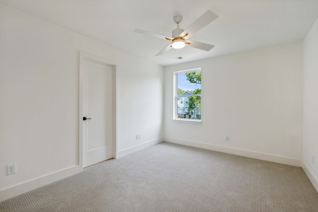 carpeted spare room featuring ceiling fan