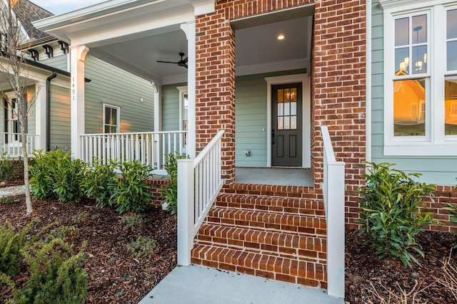 view of exterior entry featuring ceiling fan and covered porch