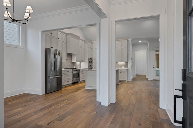 kitchen featuring crown molding, high quality appliances, decorative light fixtures, and white cabinets