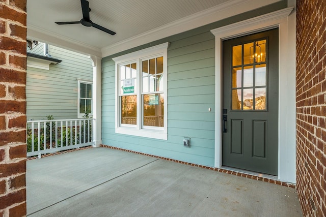 view of exterior entry featuring a porch and ceiling fan