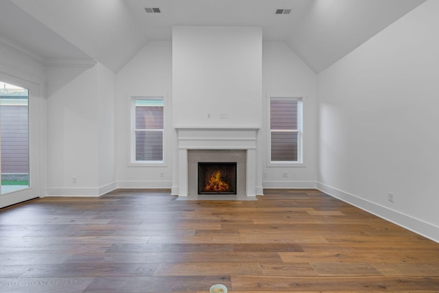 unfurnished living room featuring hardwood / wood-style flooring and lofted ceiling