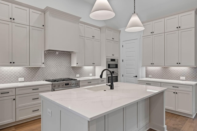 kitchen with sink, decorative light fixtures, a center island with sink, and appliances with stainless steel finishes