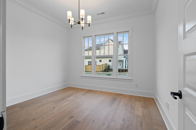 spare room featuring crown molding, an inviting chandelier, and hardwood / wood-style flooring