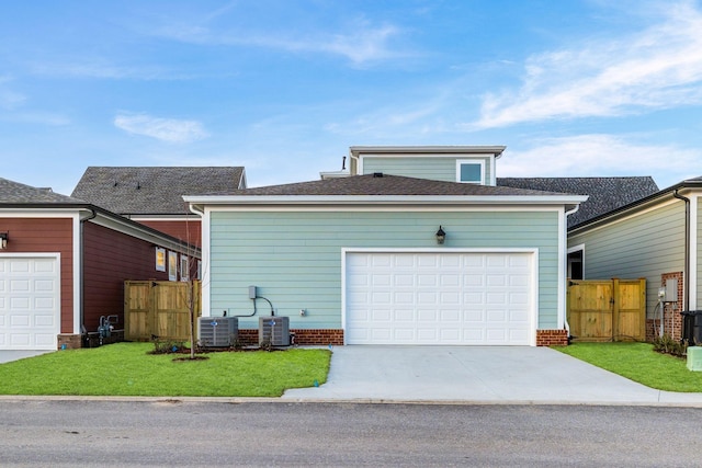 view of front of property with cooling unit, a garage, and a front lawn