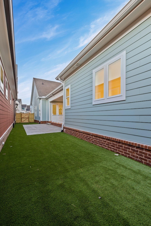 rear view of house featuring a yard and a patio