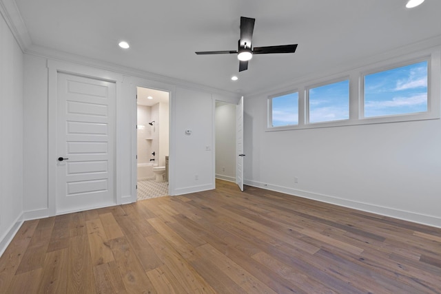 unfurnished bedroom with hardwood / wood-style floors, crown molding, ensuite bath, and ceiling fan