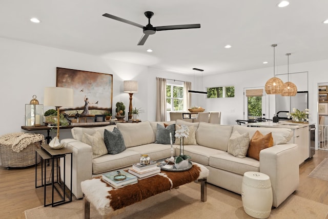 living room featuring light wood-type flooring and ceiling fan