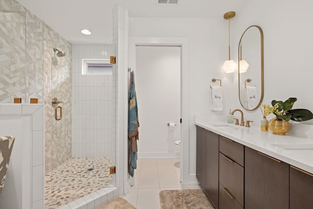 bathroom with tile patterned flooring, vanity, toilet, and a shower with door