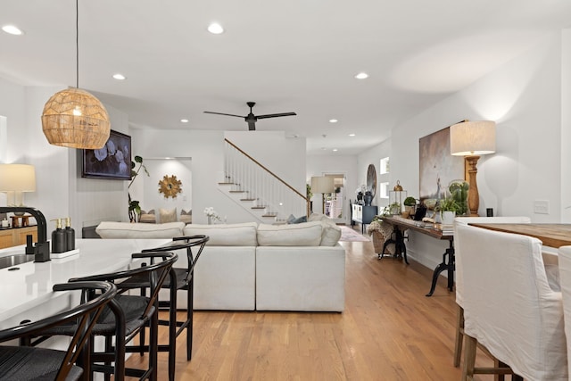 living room with ceiling fan and light hardwood / wood-style flooring