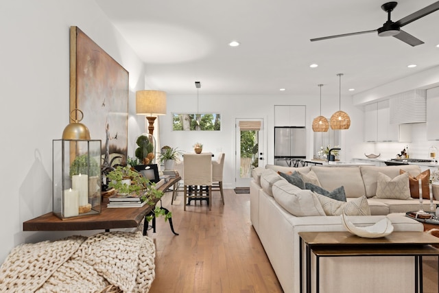 living room with ceiling fan and light hardwood / wood-style flooring