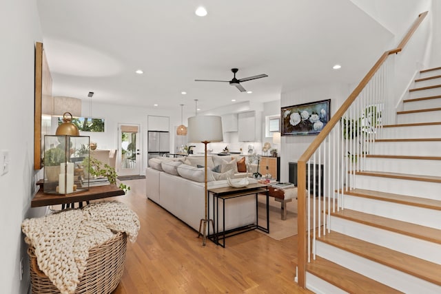 living room with light hardwood / wood-style floors and ceiling fan