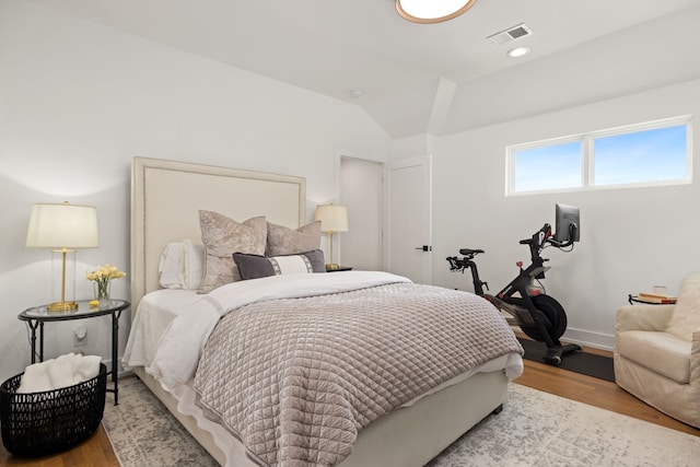 bedroom with lofted ceiling and light hardwood / wood-style flooring