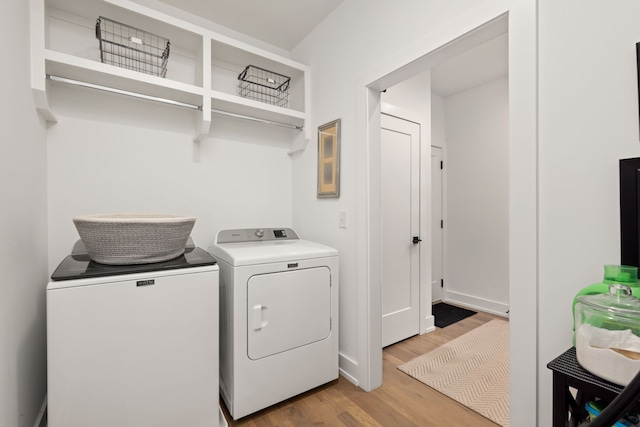 washroom with light wood-type flooring and washing machine and clothes dryer