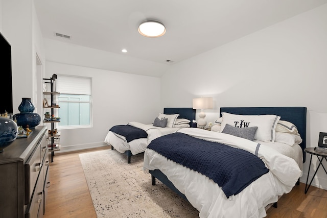 bedroom with light hardwood / wood-style flooring and lofted ceiling