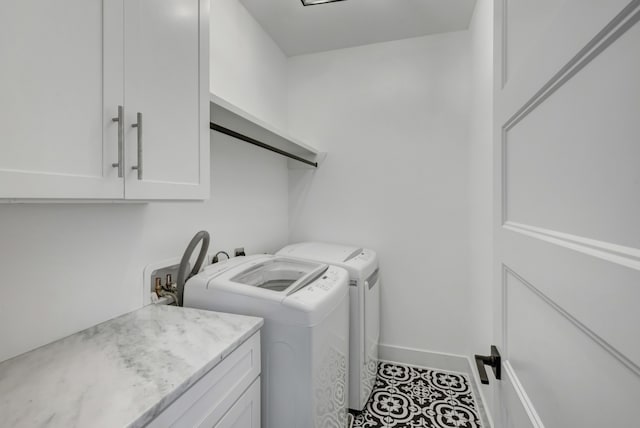 clothes washing area featuring cabinets and independent washer and dryer