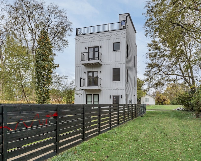 exterior space featuring a lawn and a balcony