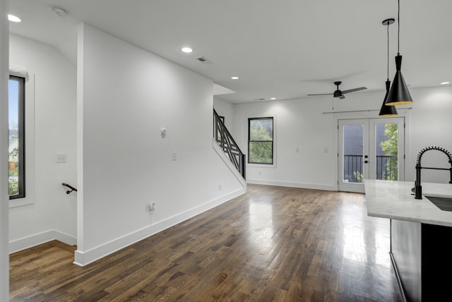 unfurnished living room featuring dark hardwood / wood-style flooring, ceiling fan, and plenty of natural light