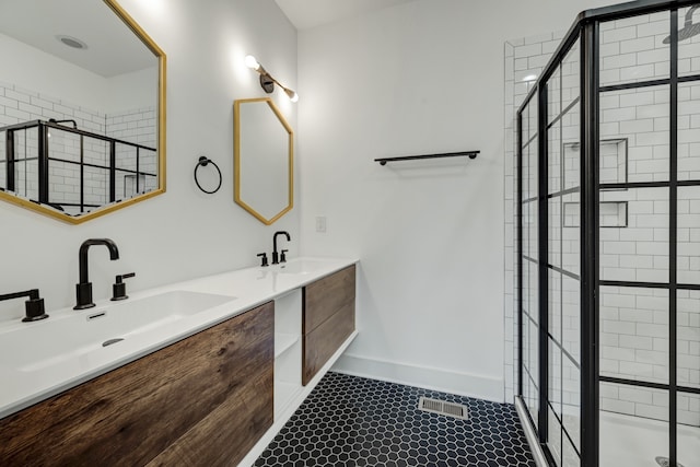 bathroom featuring vanity, tile patterned flooring, and a tile shower