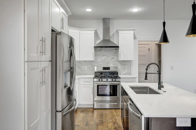 kitchen featuring white cabinetry, appliances with stainless steel finishes, sink, and wall chimney range hood