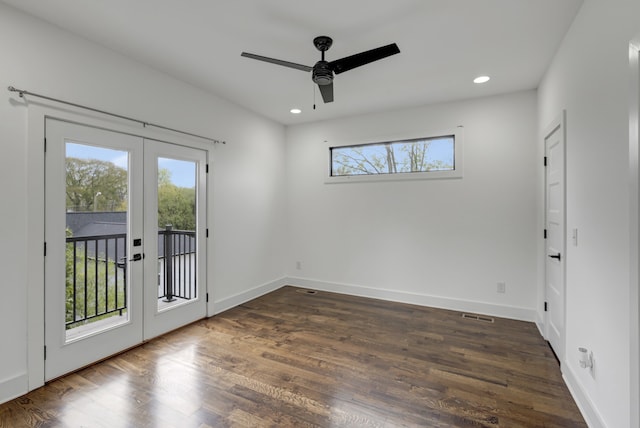 spare room with french doors, plenty of natural light, and dark hardwood / wood-style floors