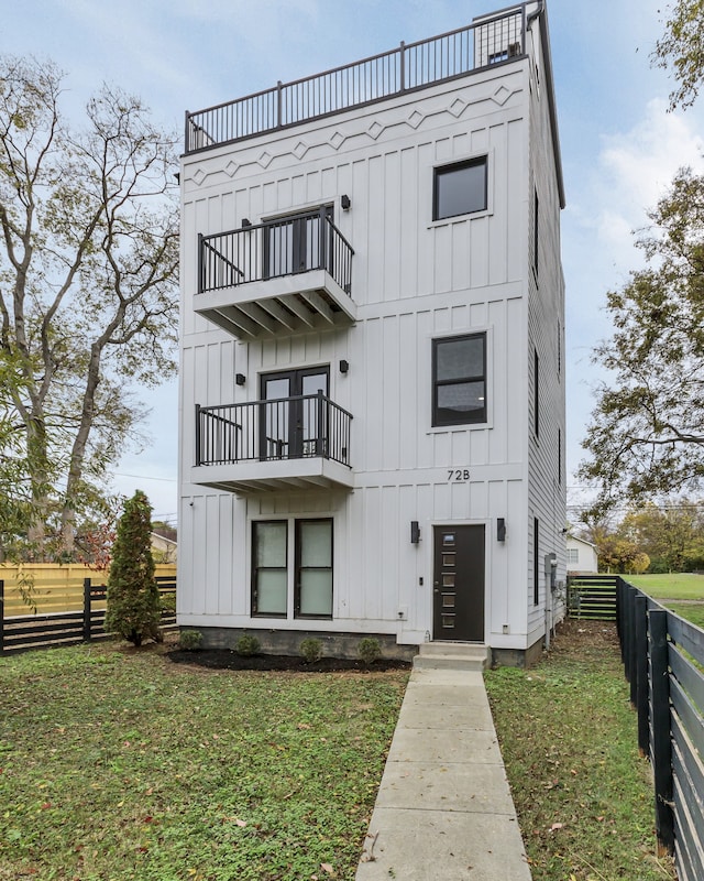 view of front facade featuring a front yard and a balcony