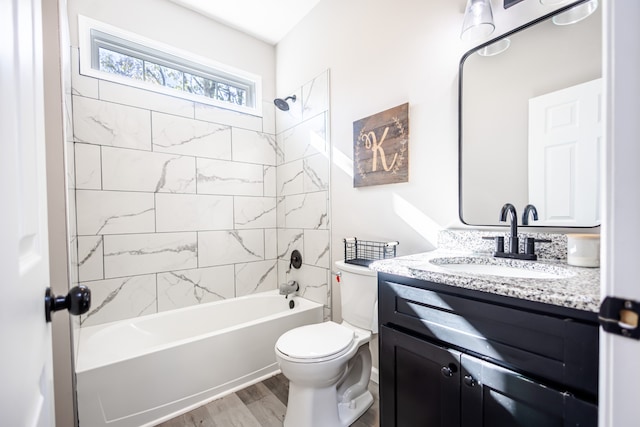 full bathroom featuring toilet, vanity, wood-type flooring, and tiled shower / bath