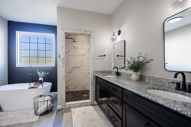 bathroom featuring hardwood / wood-style flooring, vanity, and plus walk in shower